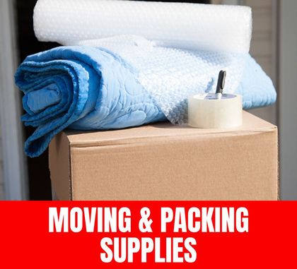 Stacks of labeled moving boxes, packing tape, bubble wrap, and other packing materials ready for use.