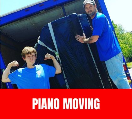 Trained movers carefully securing and lifting an upright piano onto a moving dolly with protective padding and straps.