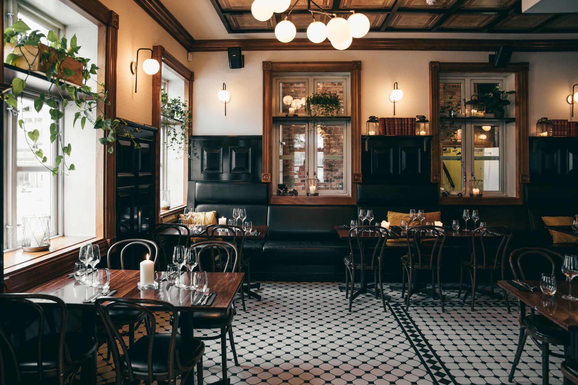 En restaurant med bord og stoler og et rutete gulv.