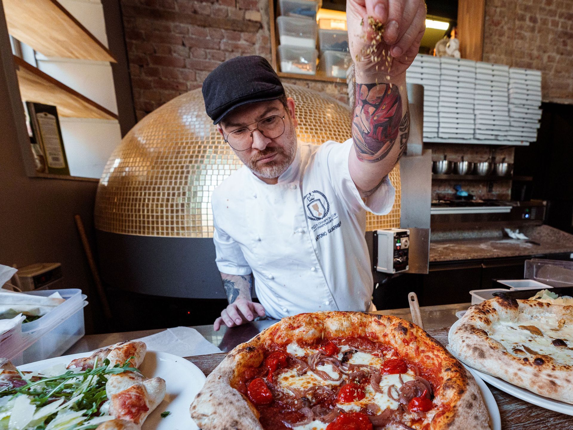 En mann står foran en pizzaovn.