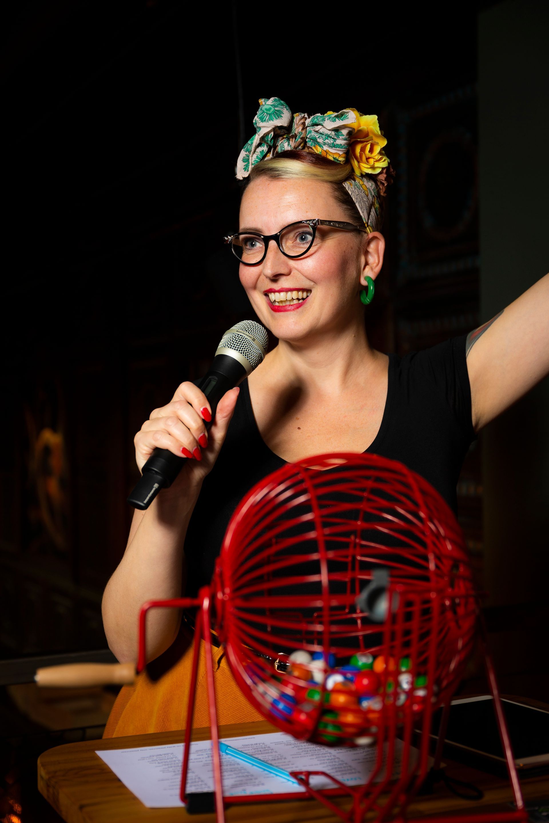 En kvinne holder en mikrofon foran en bingomaskin.