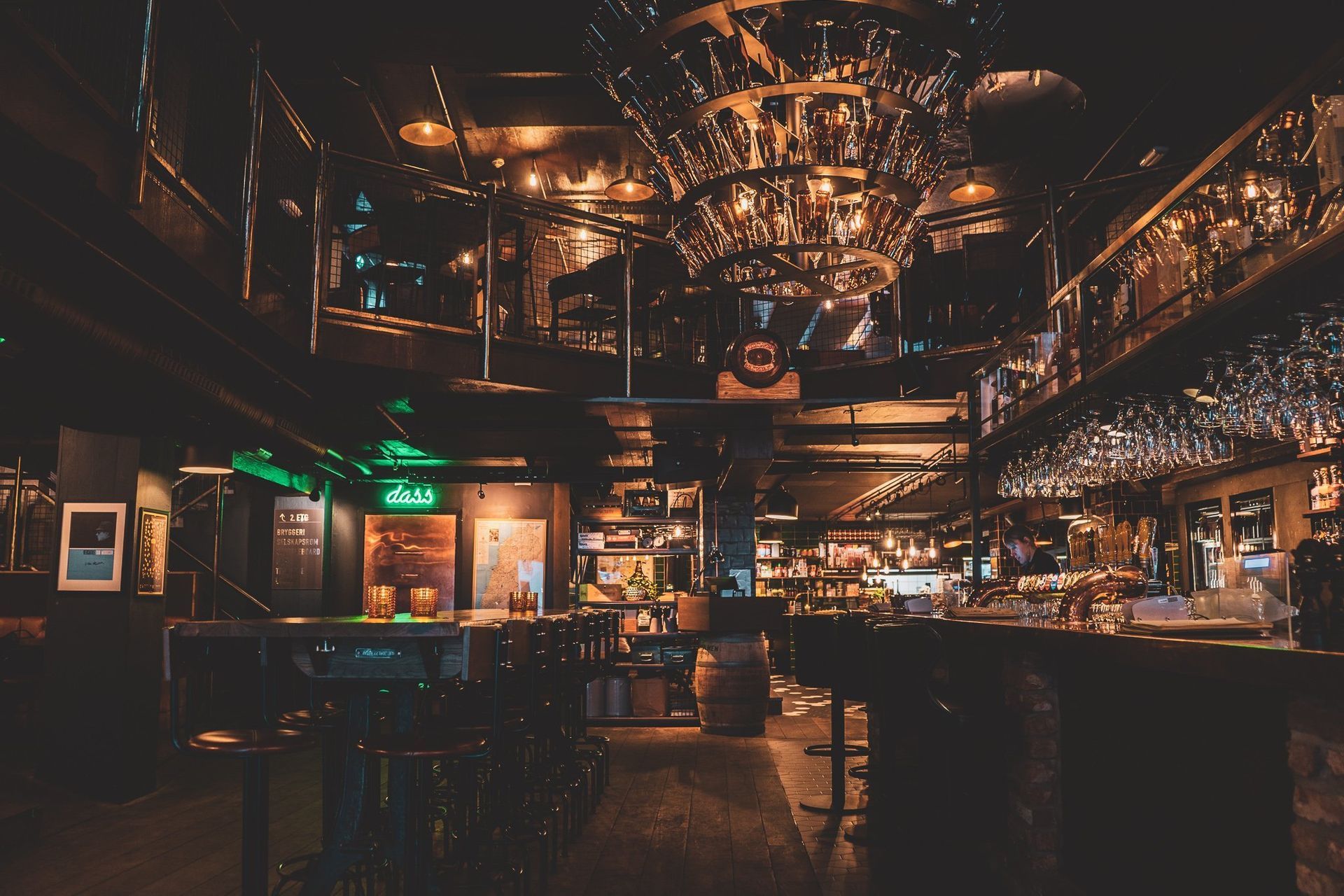 En stor, tom restaurant med mange bord og stoler og en lysekrone som henger fra taket.