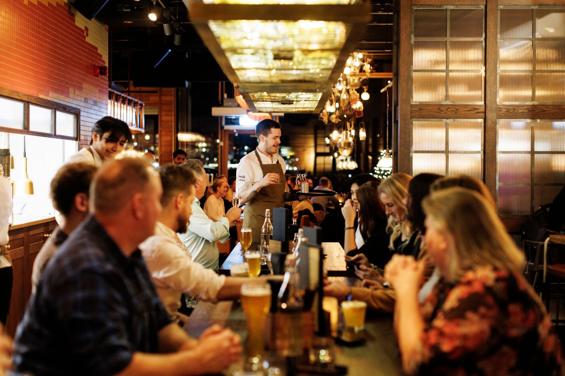 En gruppe mennesker sitter ved bordene på en restaurant.