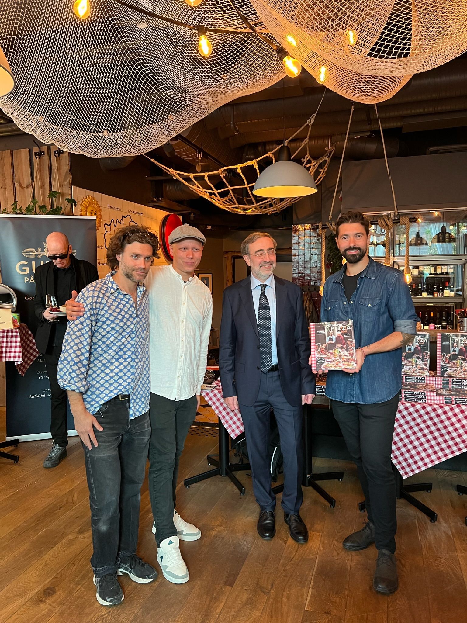 En gruppe menn poserer på en restaurant.