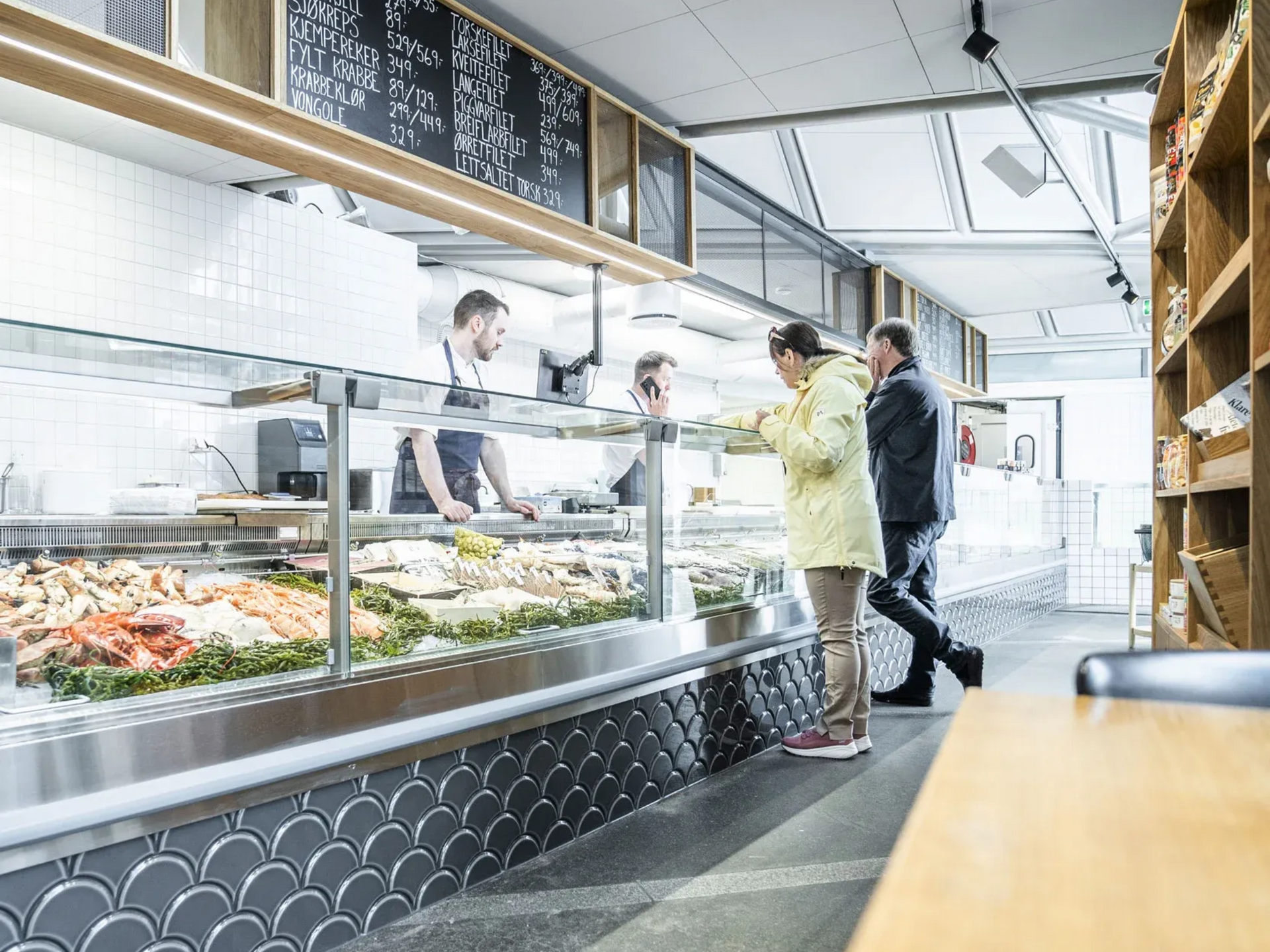 Kunder bestiller sjømat fra en fiskedisk.