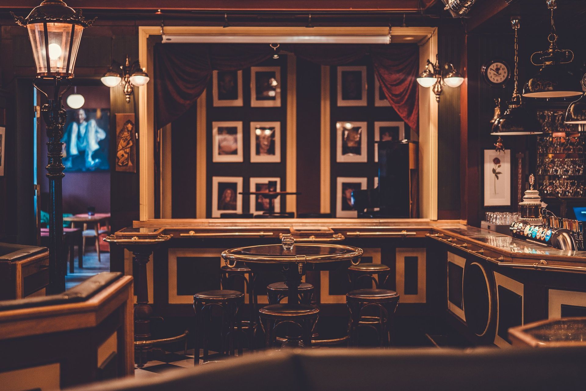 En bar med bord og stoler og en klokke på veggen.