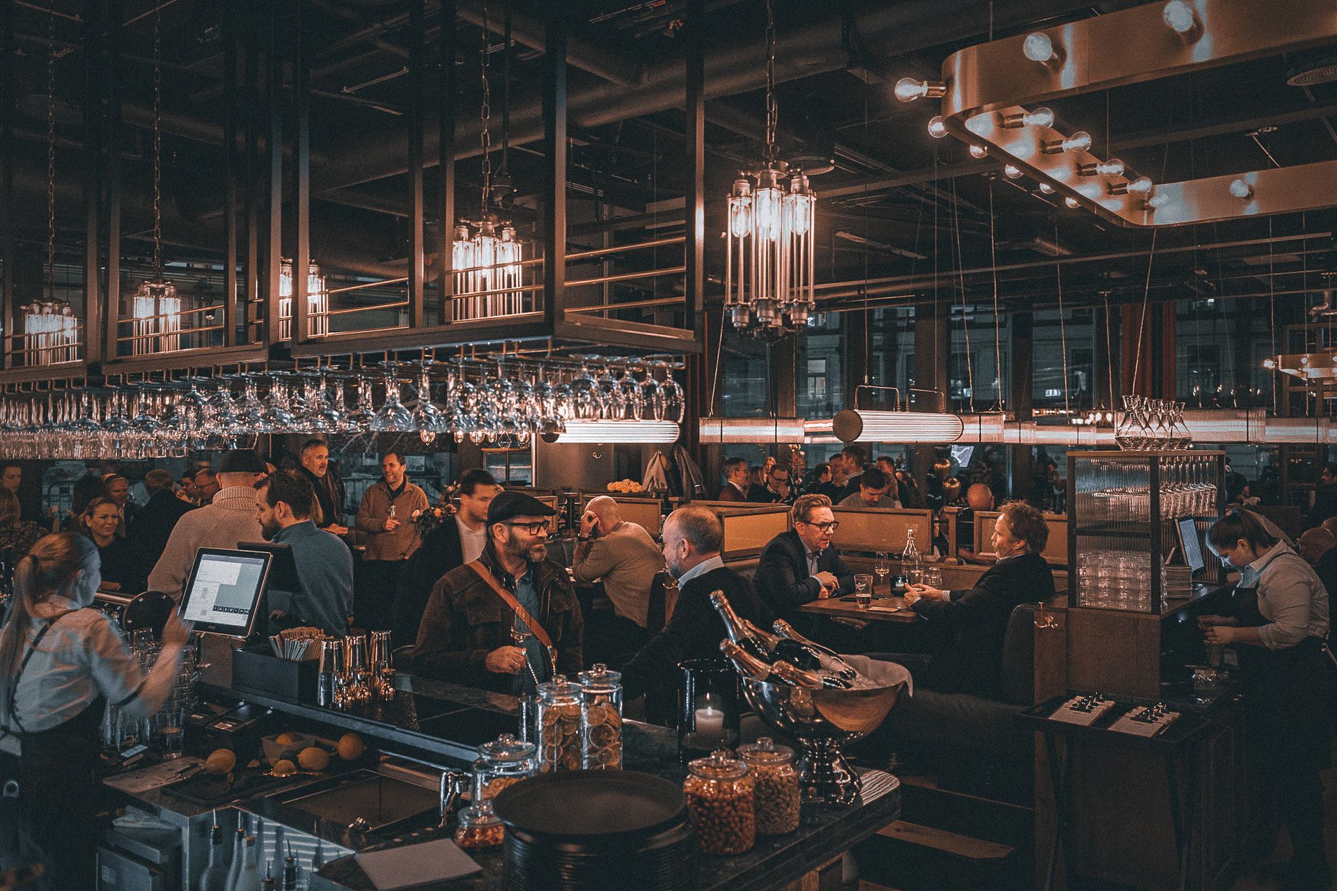 En gruppe mennesker sitter ved bordene på en restaurant.