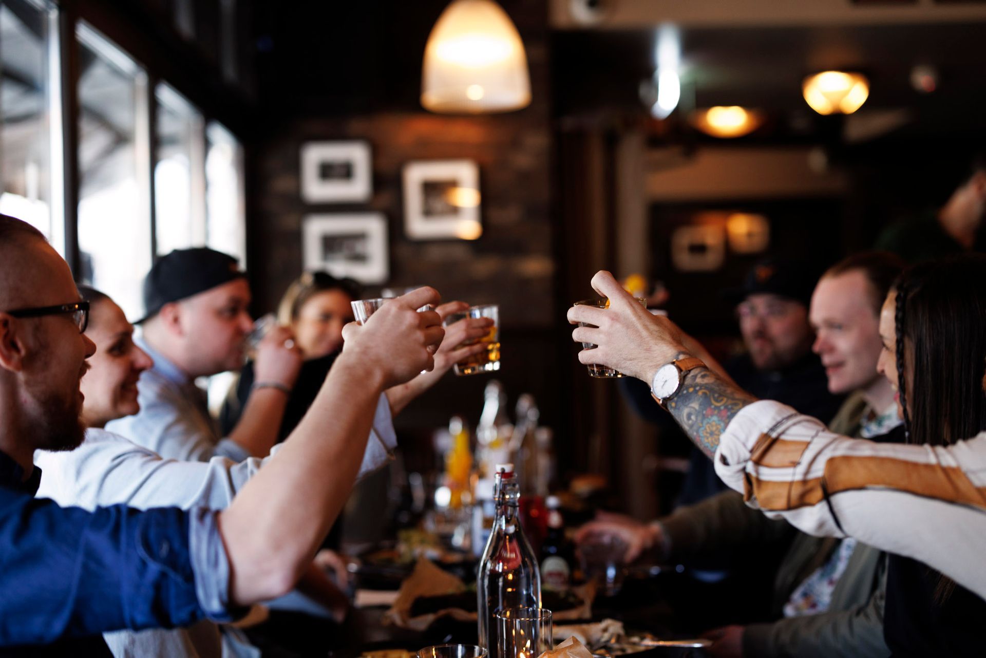 En gruppe mennesker skåler med glassene på en restaurant.