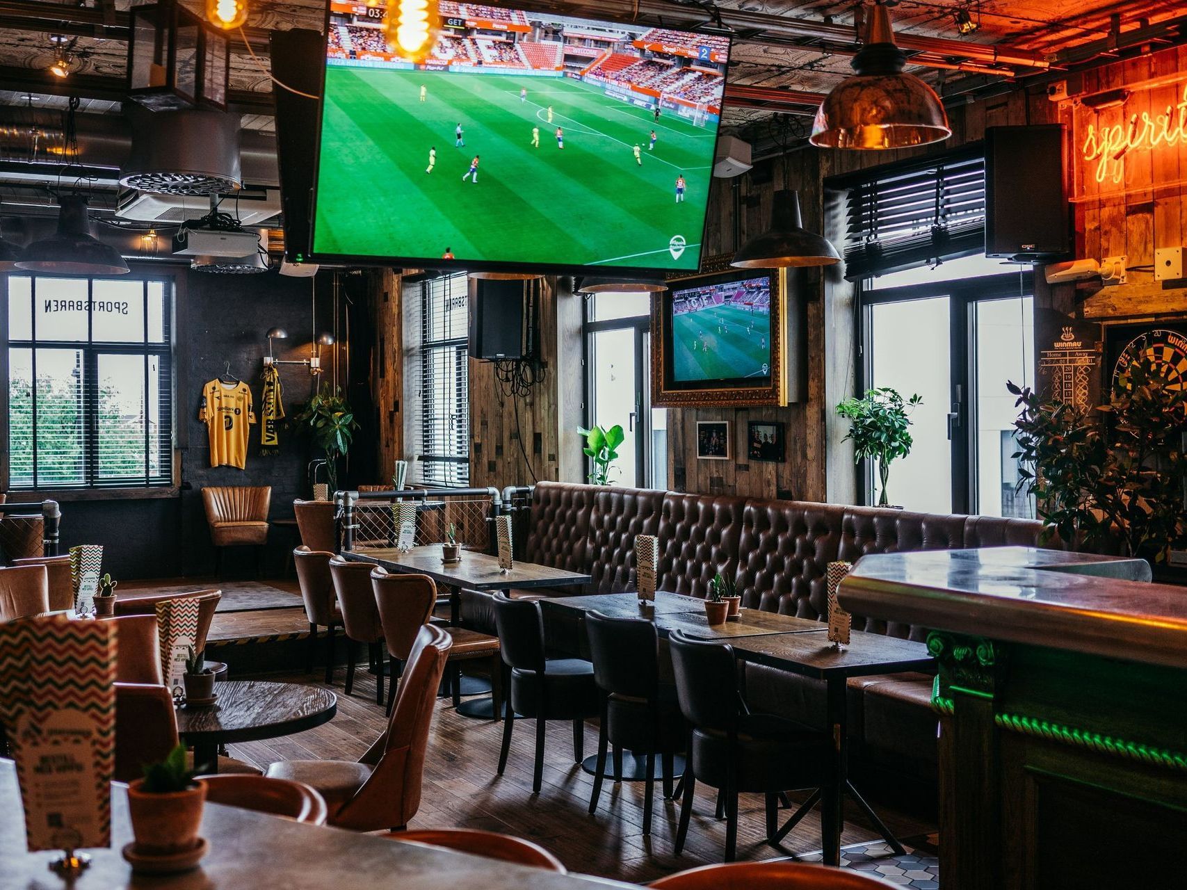 En fotballkamp spilles på en storskjerm på en restaurant.
