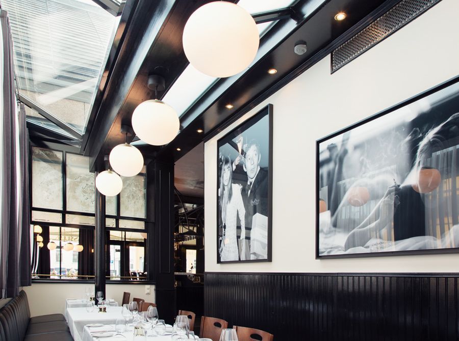 En restaurant med bord og stoler og malerier på veggen