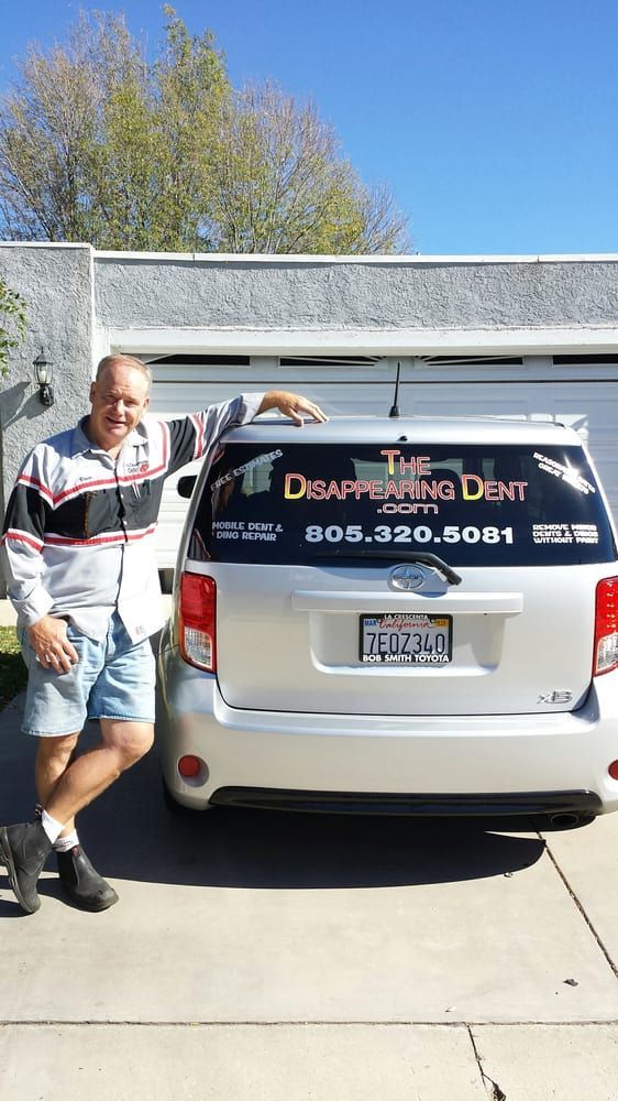 Vince is standing in front of the business car.