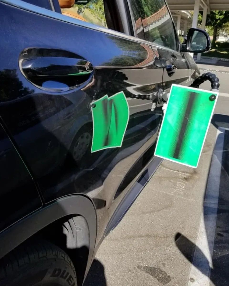 A black car with a green tag on the door