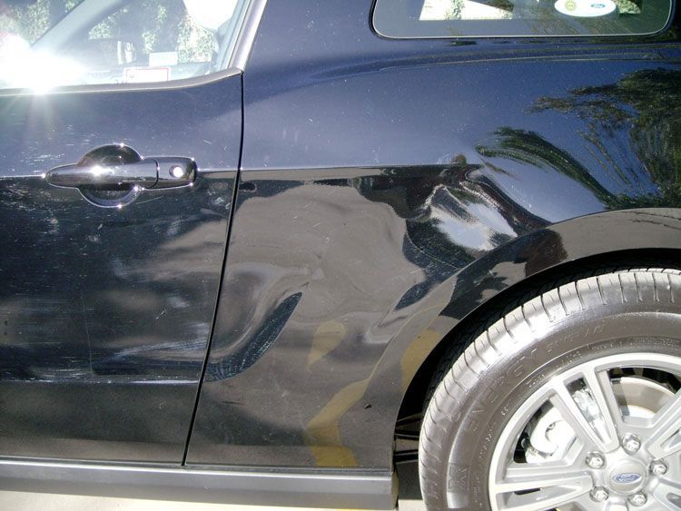 A black car is parked in a parking lot