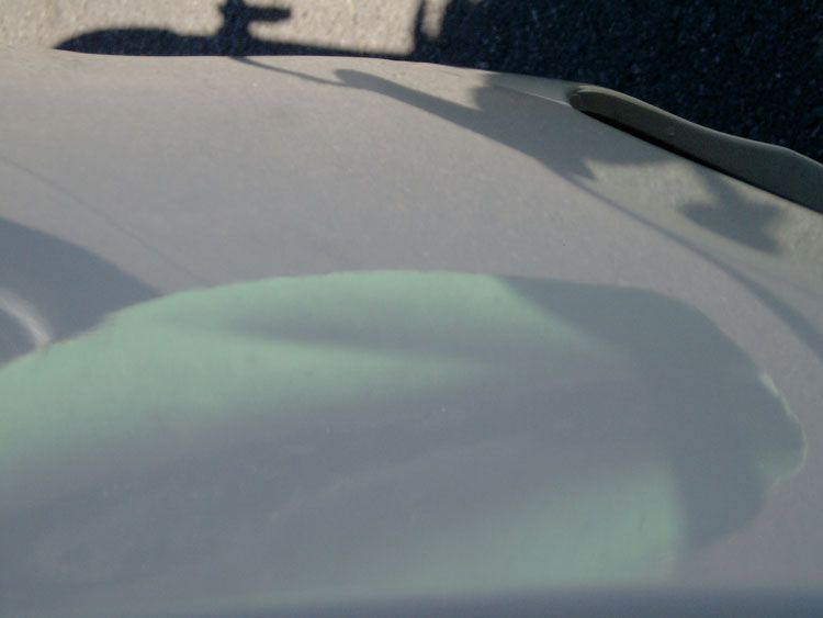 A close up of a car windshield with a shadow on it
