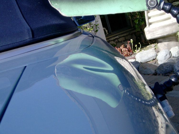 A close up of a car windshield with a green object on it