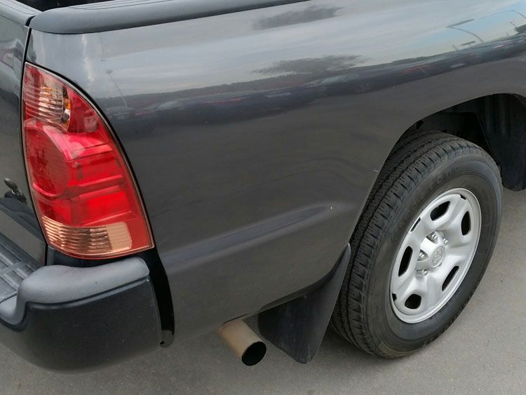 The back of a gray truck with a red tail light