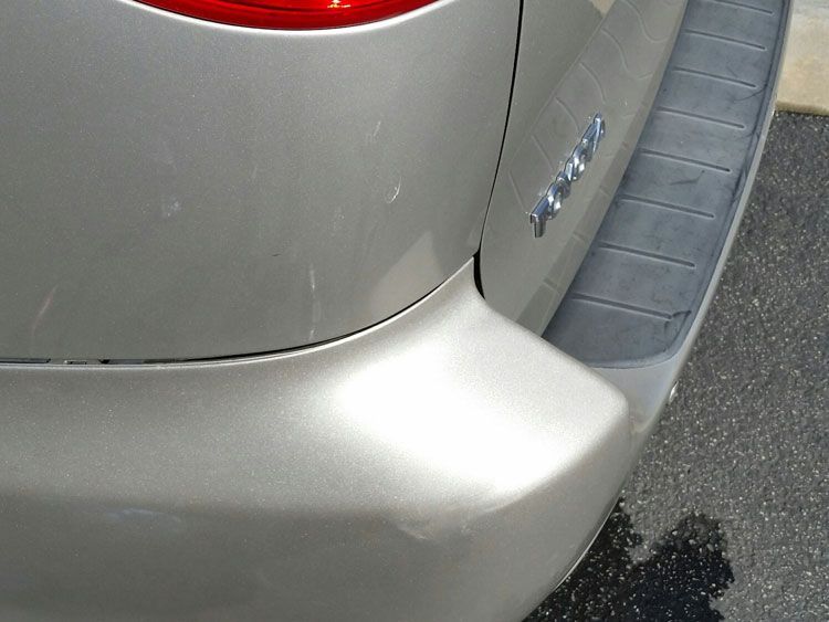 A silver minivan is parked on the side of the road