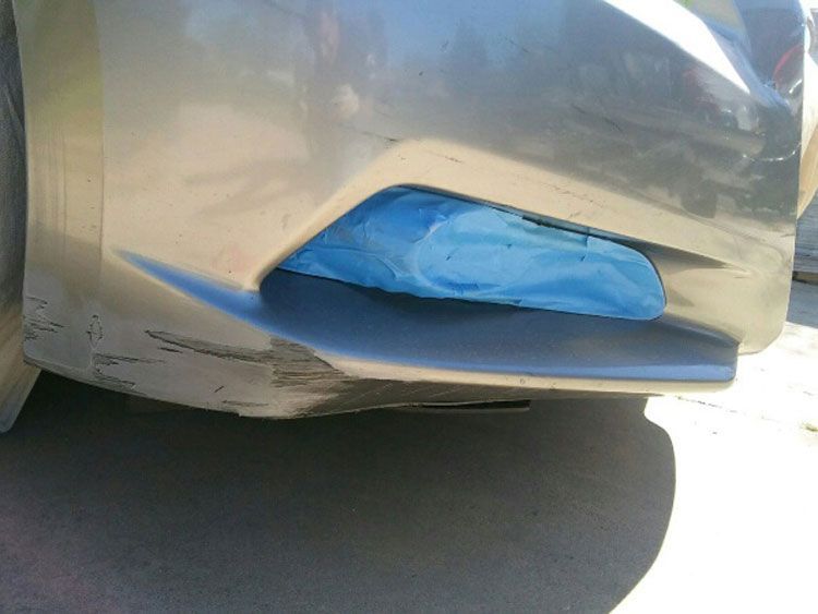 A close up of a car bumper with a blue cloth on it