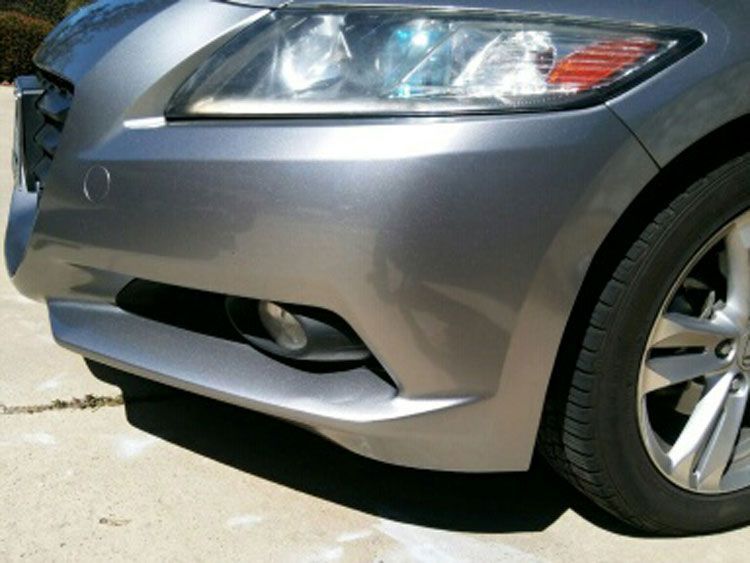 A silver car is parked on the side of the road