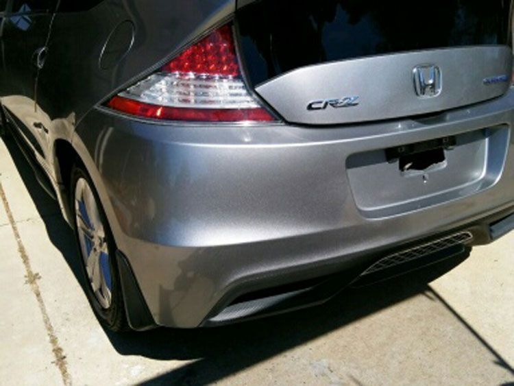 A silver honda cr-z is parked in a driveway