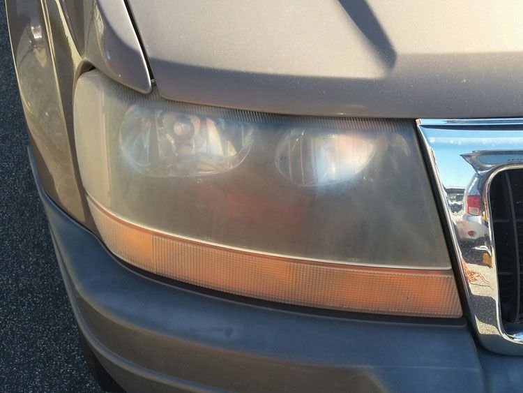 A close up of a car 's headlight and hood