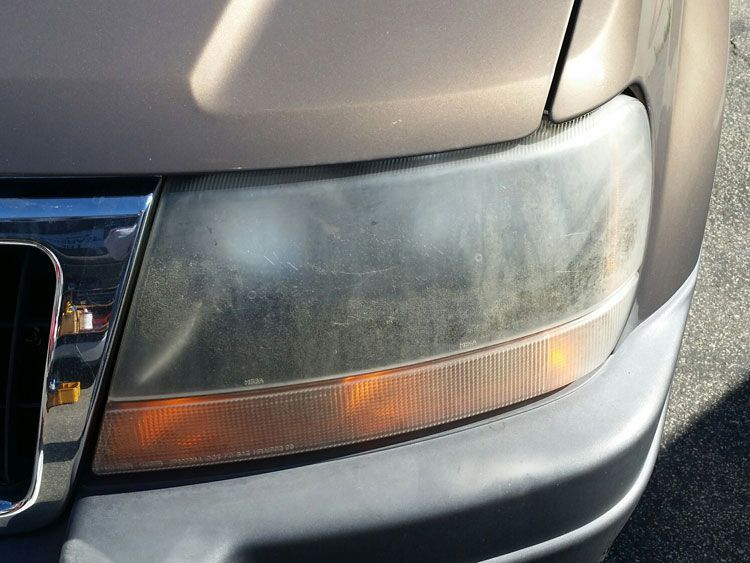 A close up of a dirty headlight on a car