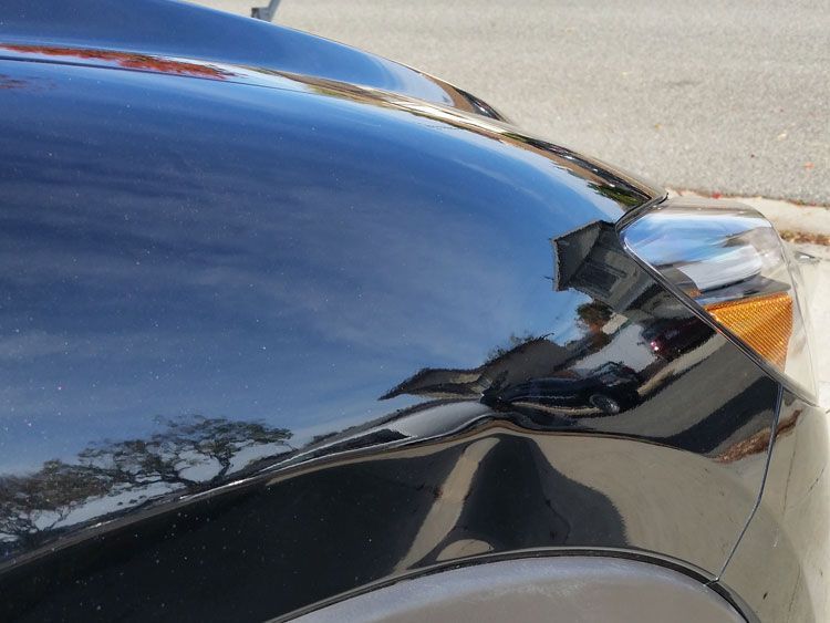 A black car is parked on the side of the road