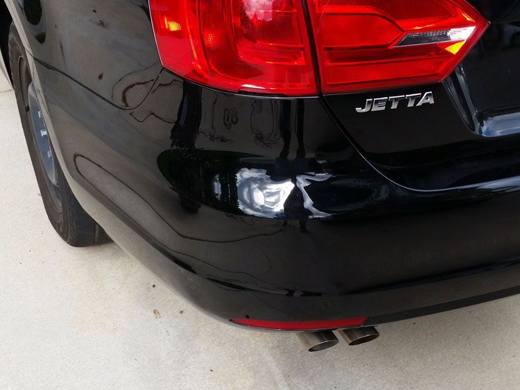 A black volkswagen jetta is parked in a driveway