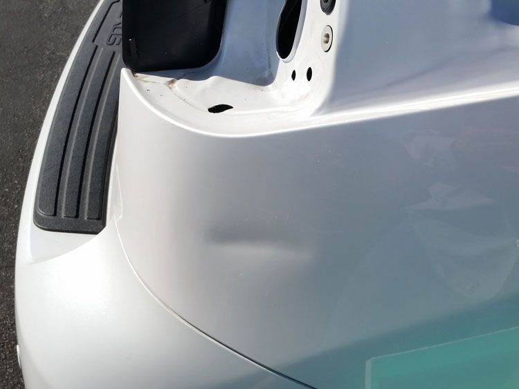 A white car is parked on the side of the road