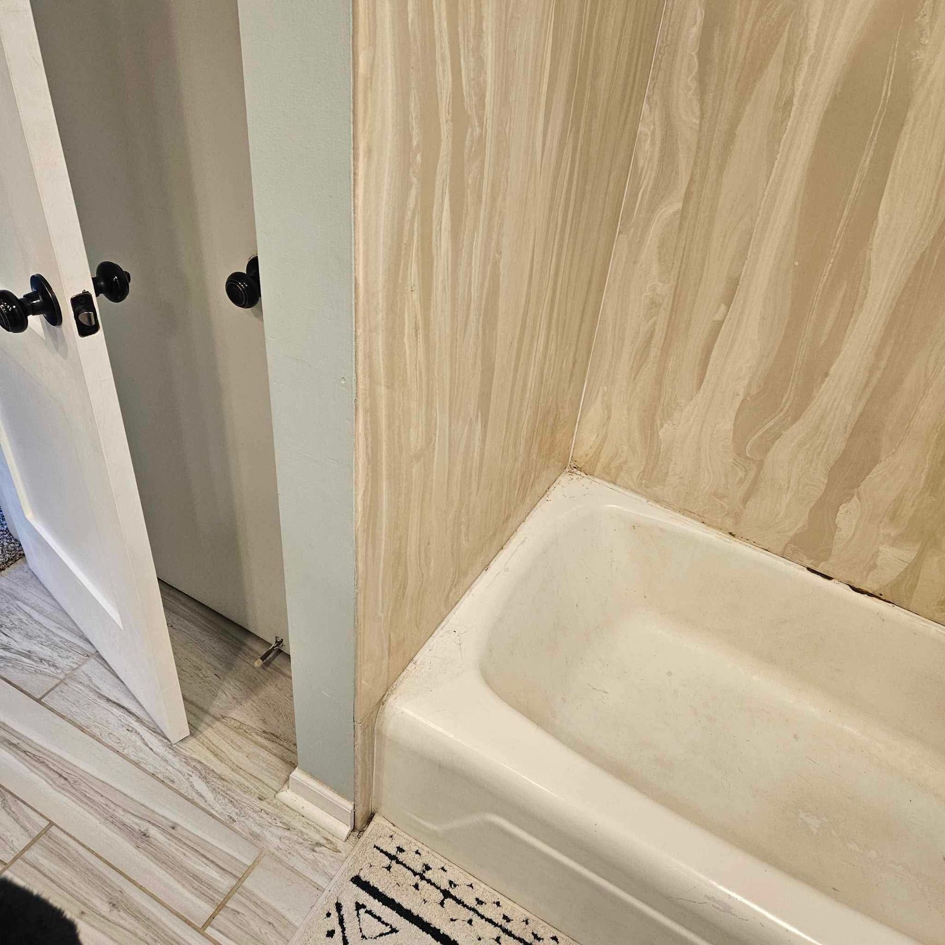 A bathroom with a bathtub and a door.