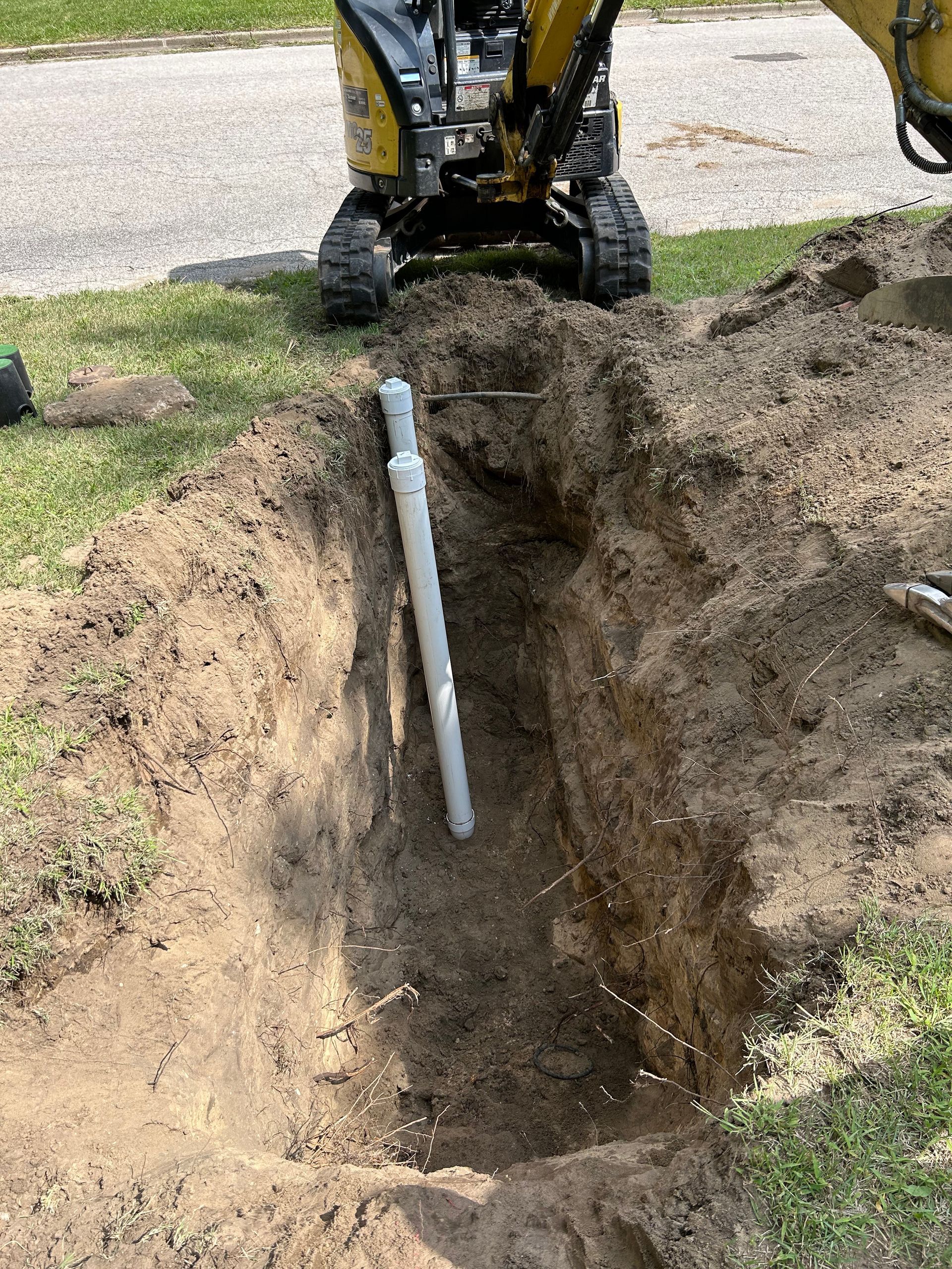 A pipe is being installed in a hole in the ground.