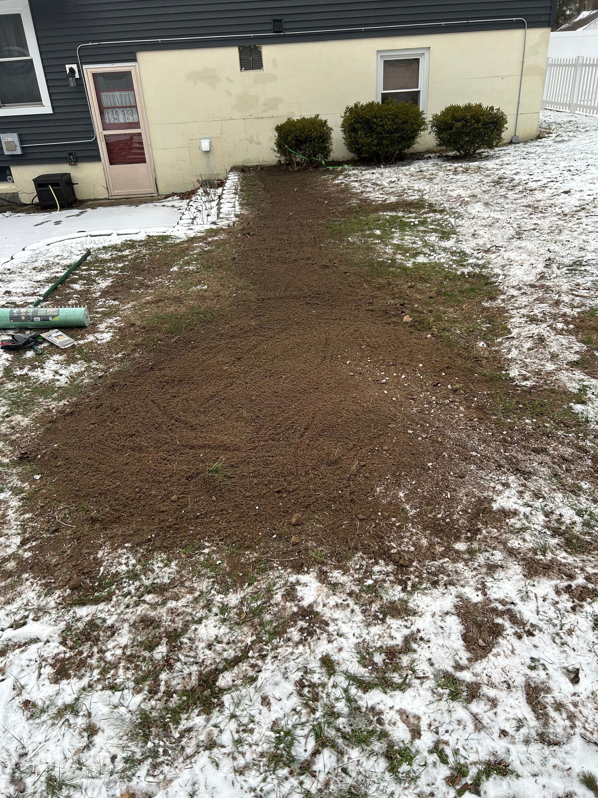 There is a lot of snow on the ground in front of a house.