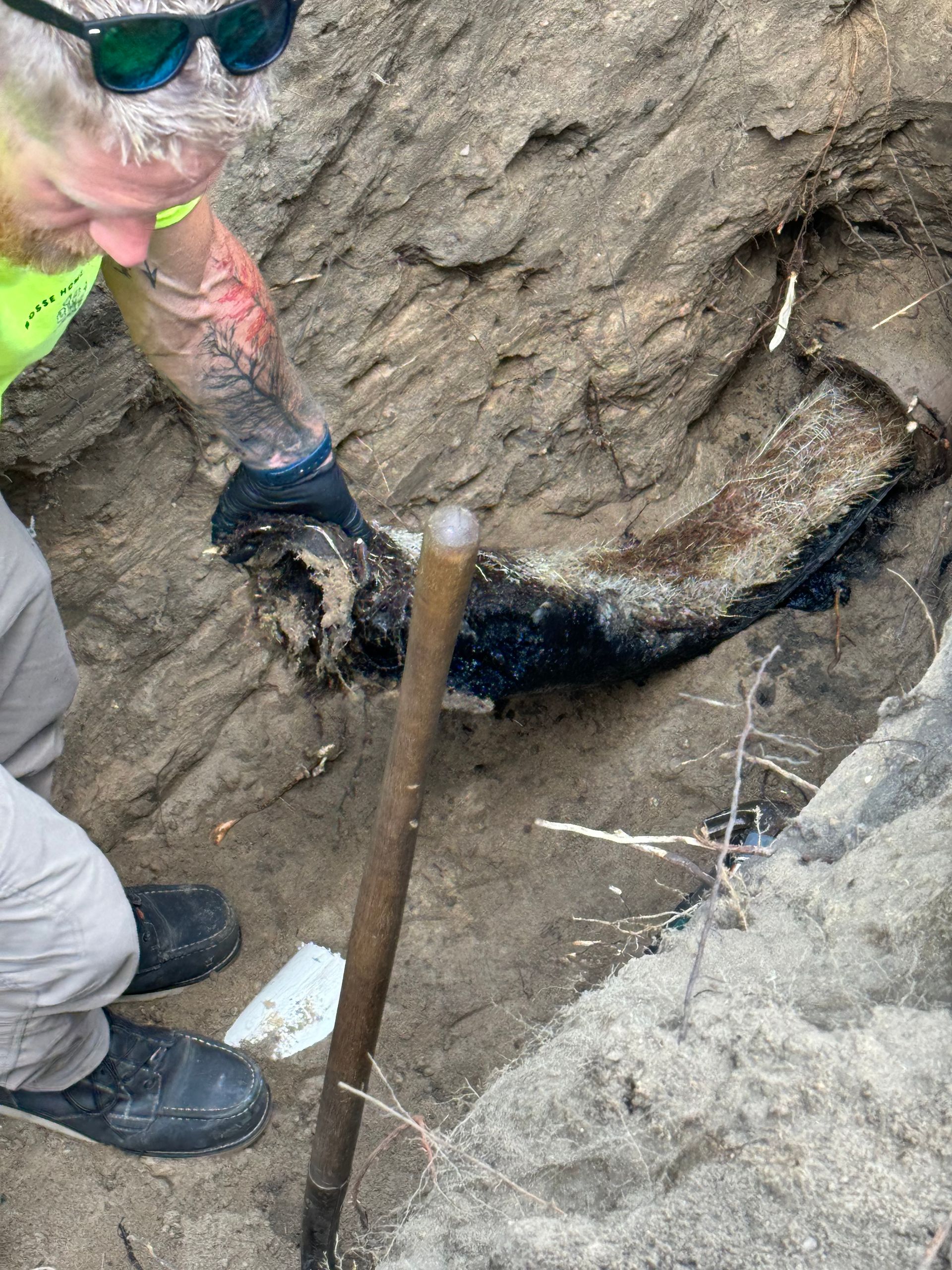 A man is digging in the dirt with a shovel.
