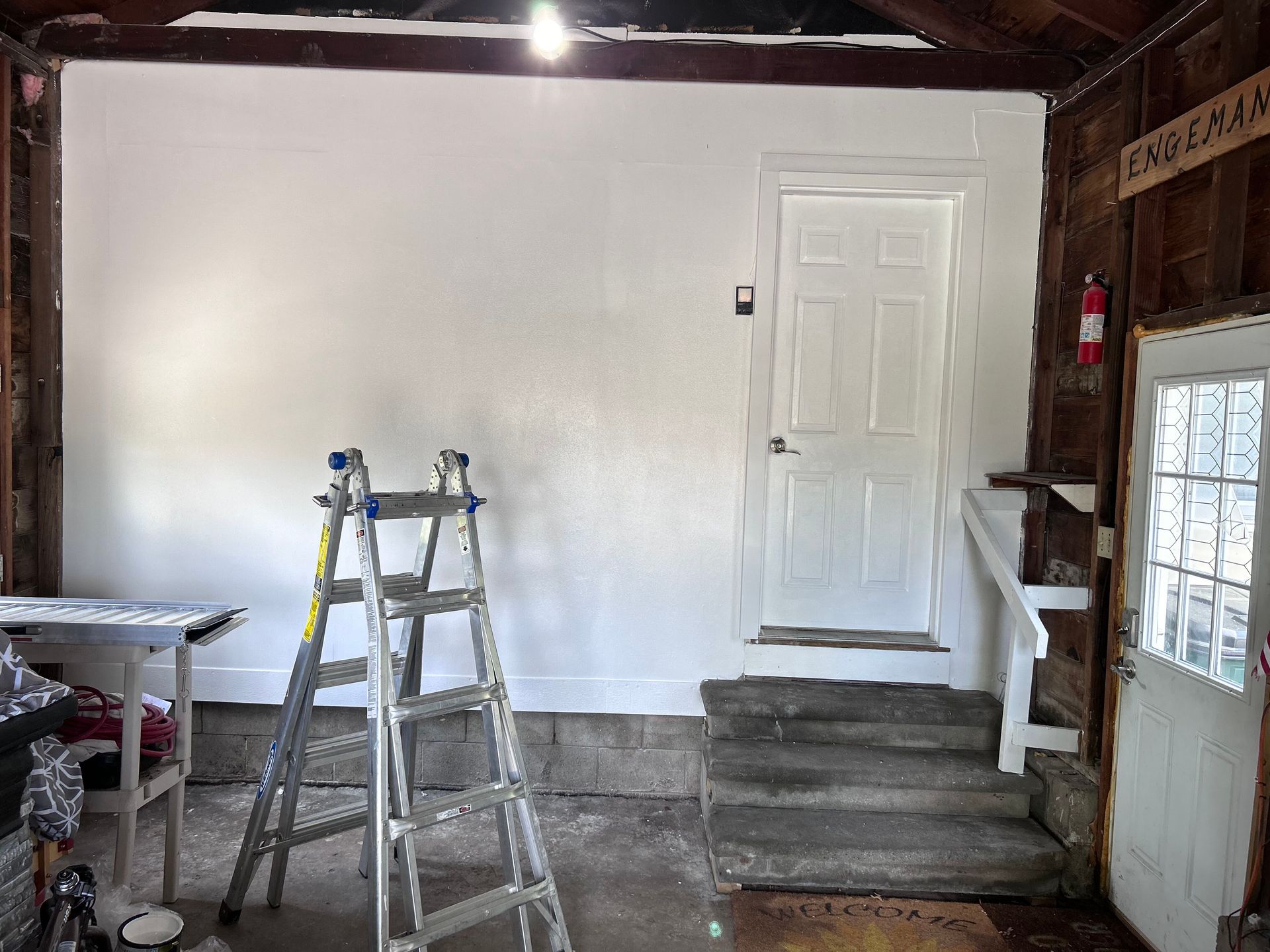 A ladder is sitting in a room next to a door.