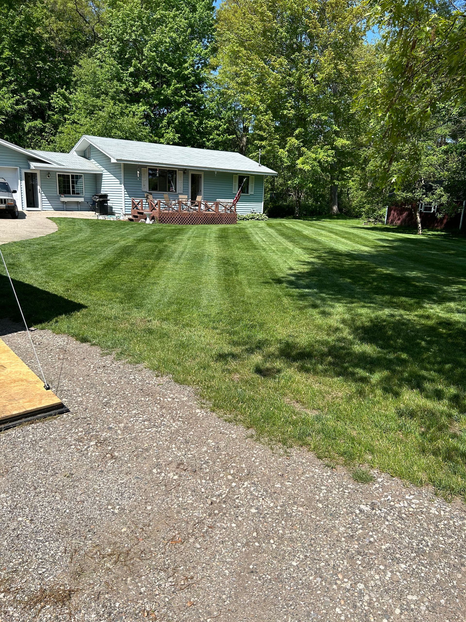 A house with a lush green lawn in front of it.