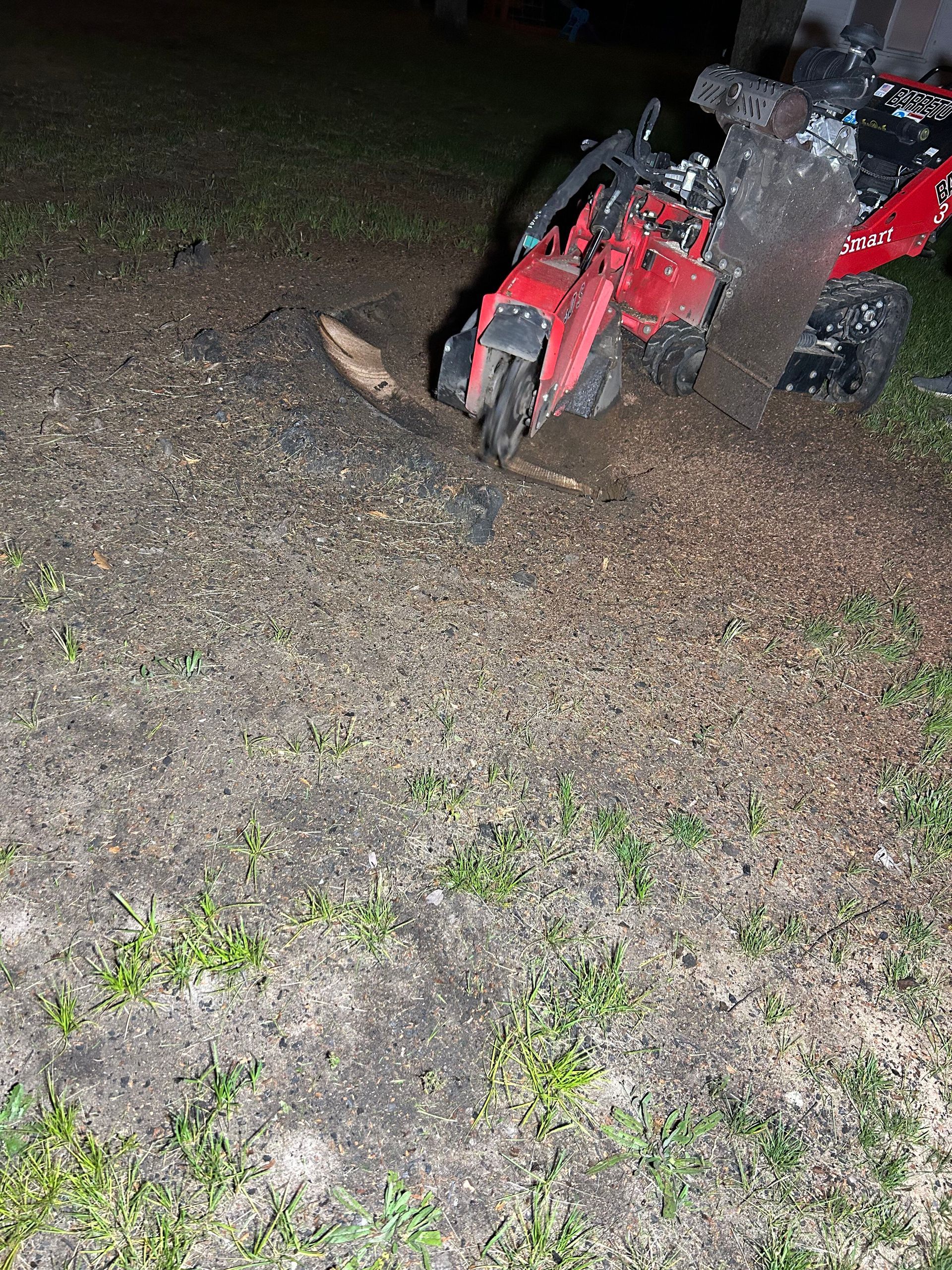 A red motorcycle is sitting on top of a dirt field.
