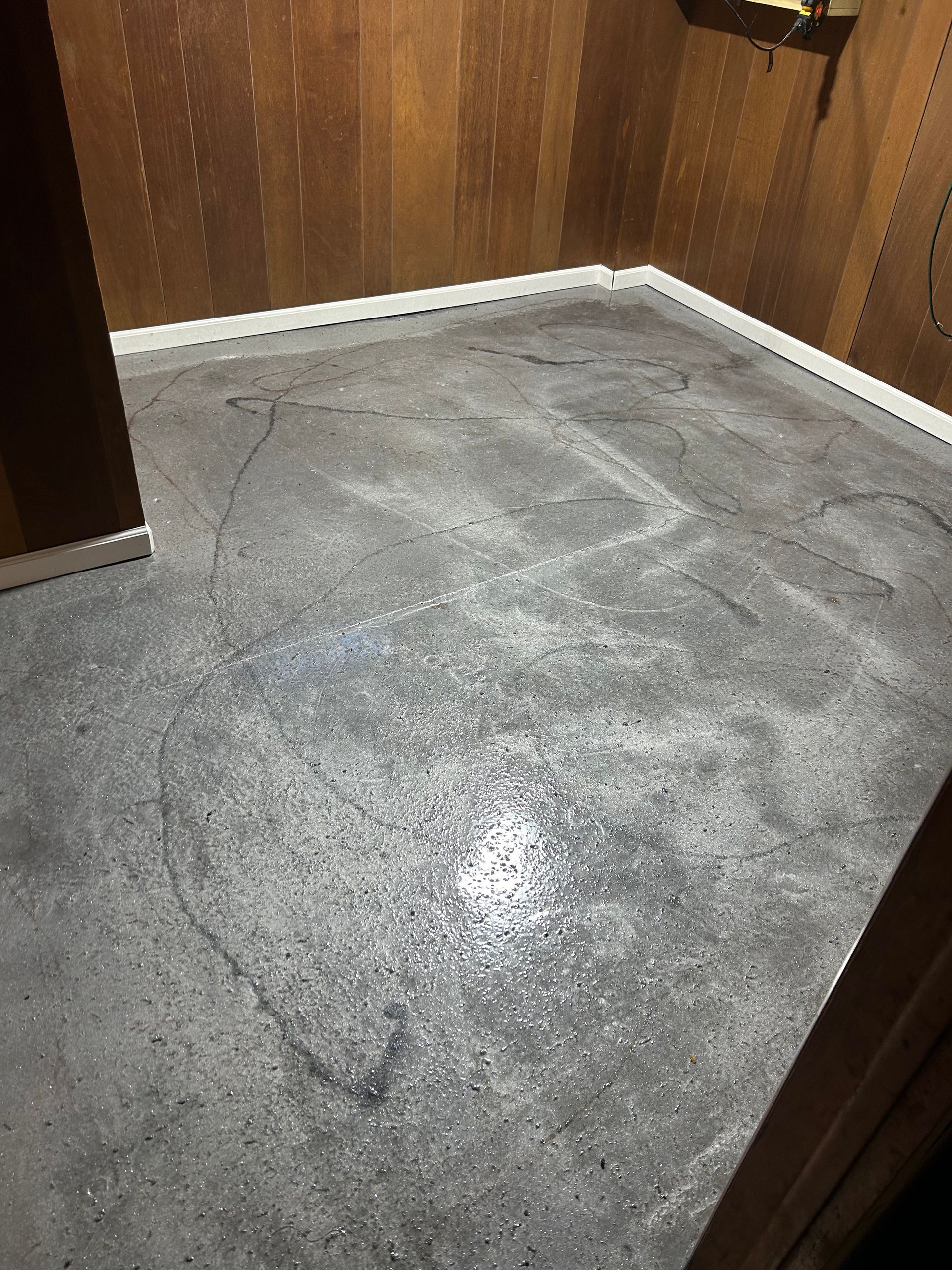 A room with a concrete floor and wooden walls.