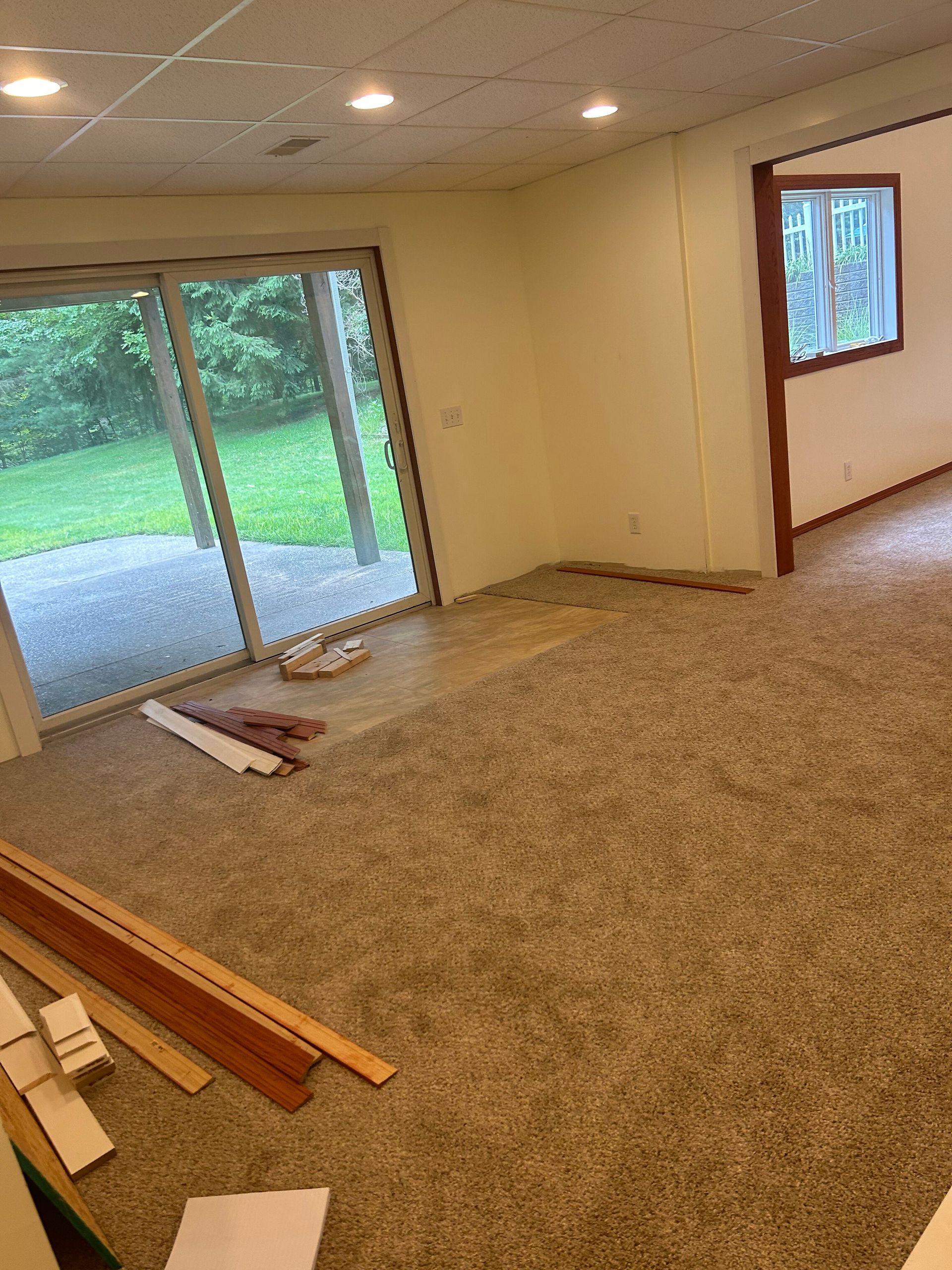 An empty room with a sliding glass door and a window.
