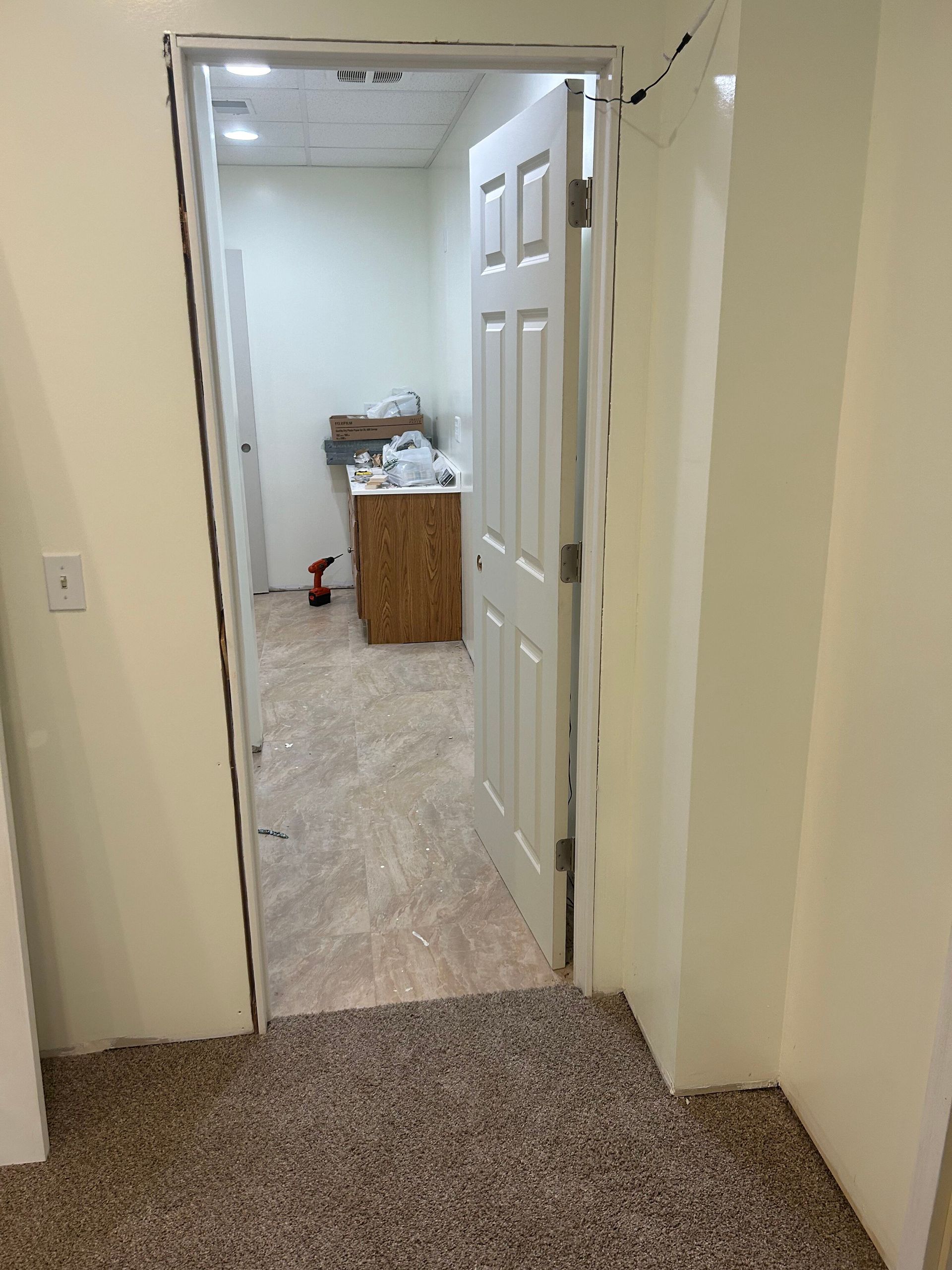 A door is open in a room with a carpeted floor.