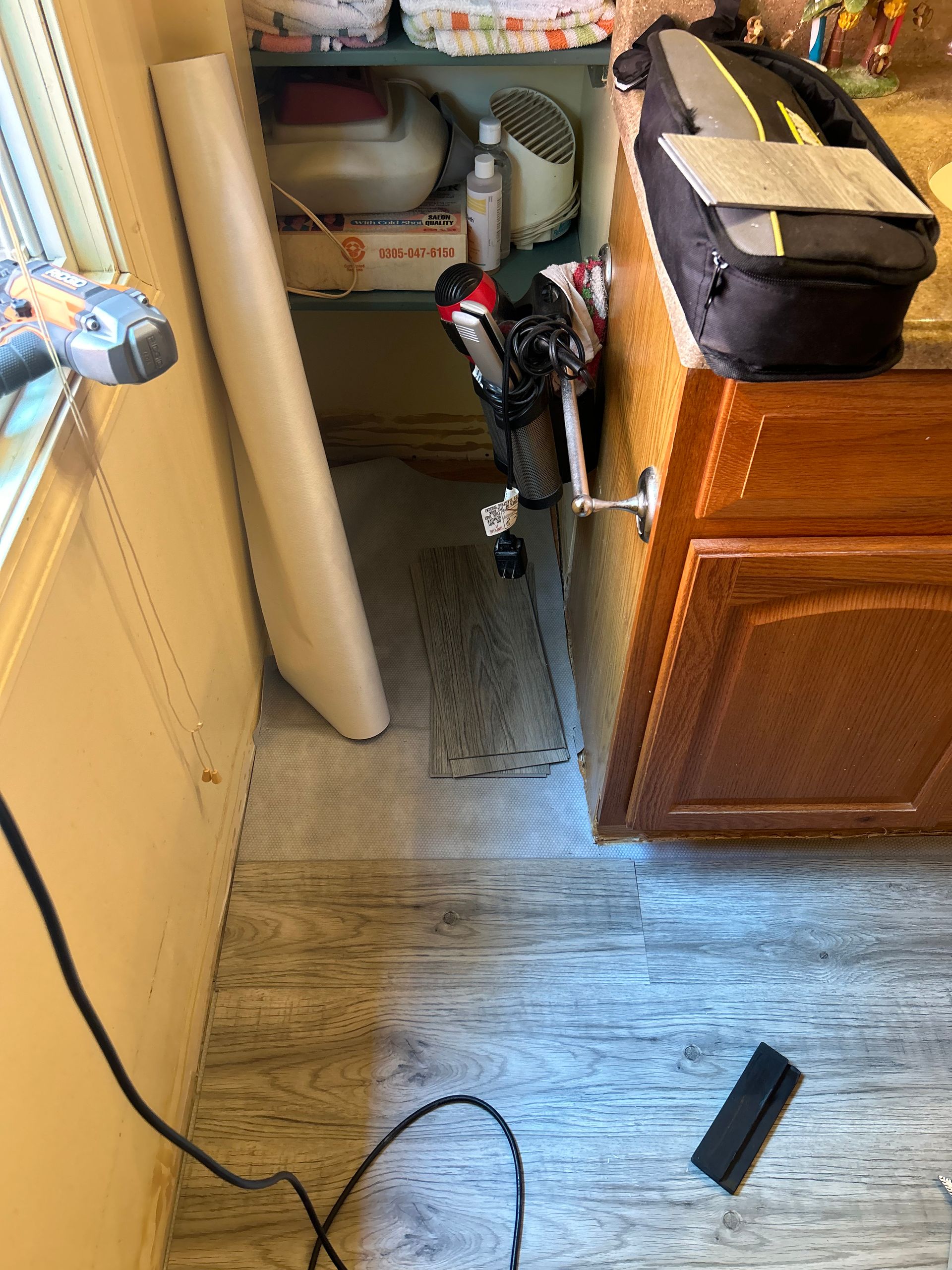 A kitchen with a sink , cabinets , and a window.