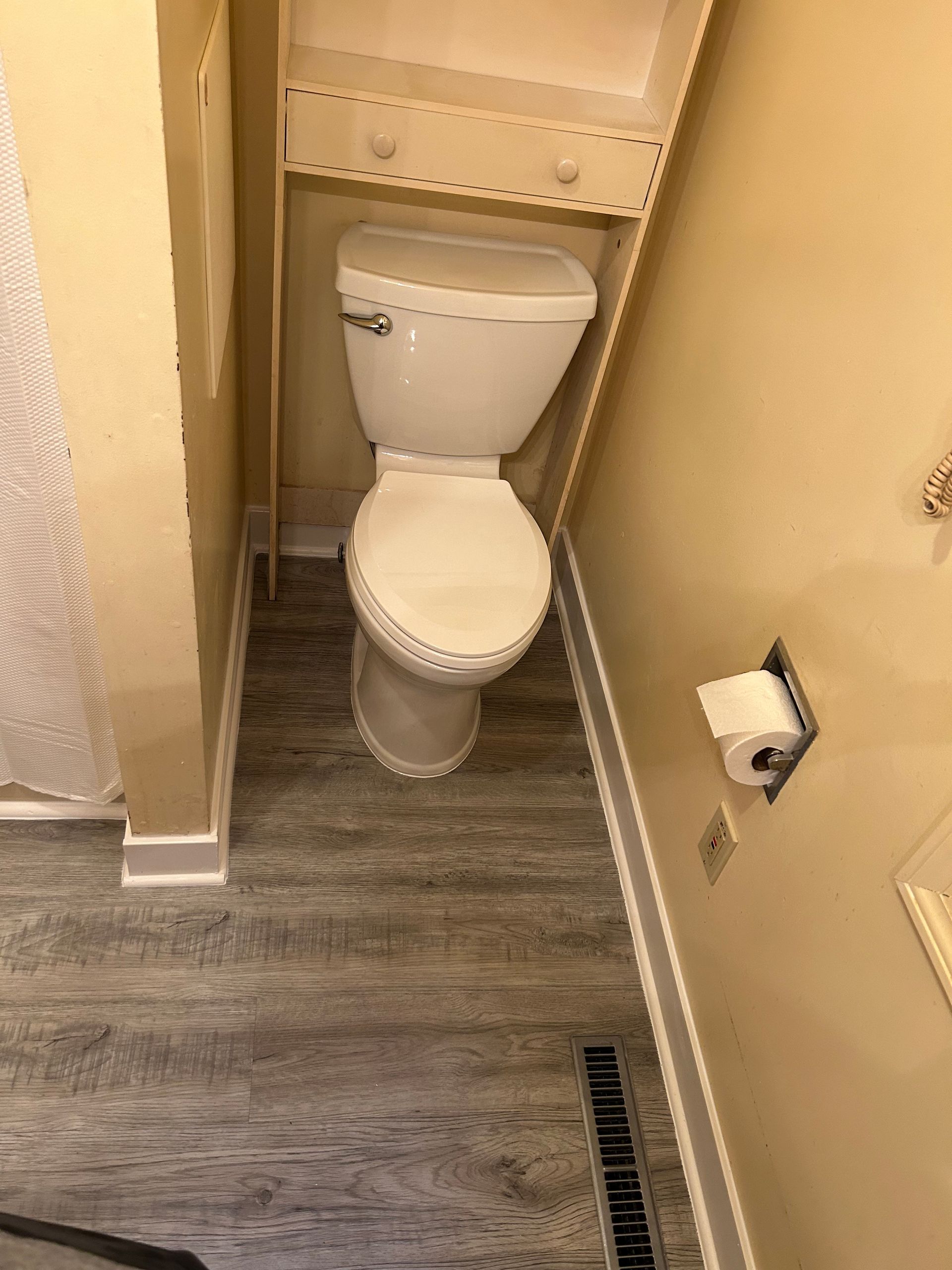 A bathroom with a toilet and a paper towel holder.