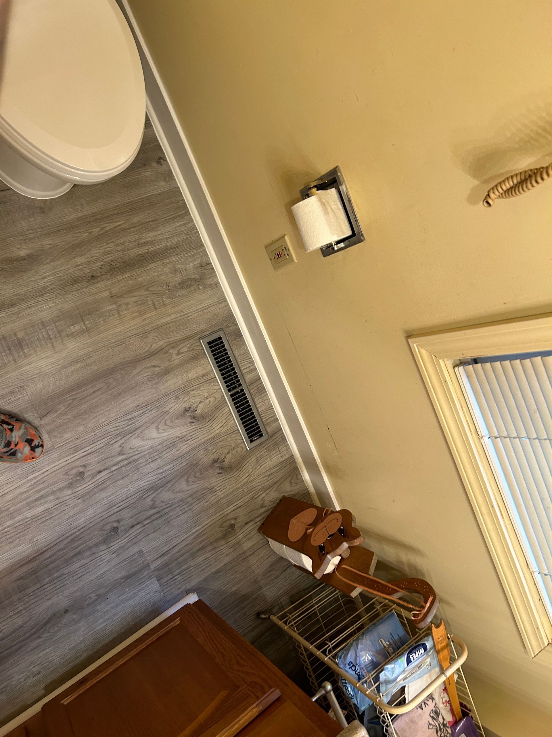 A bathroom with a toilet , sink , and window.