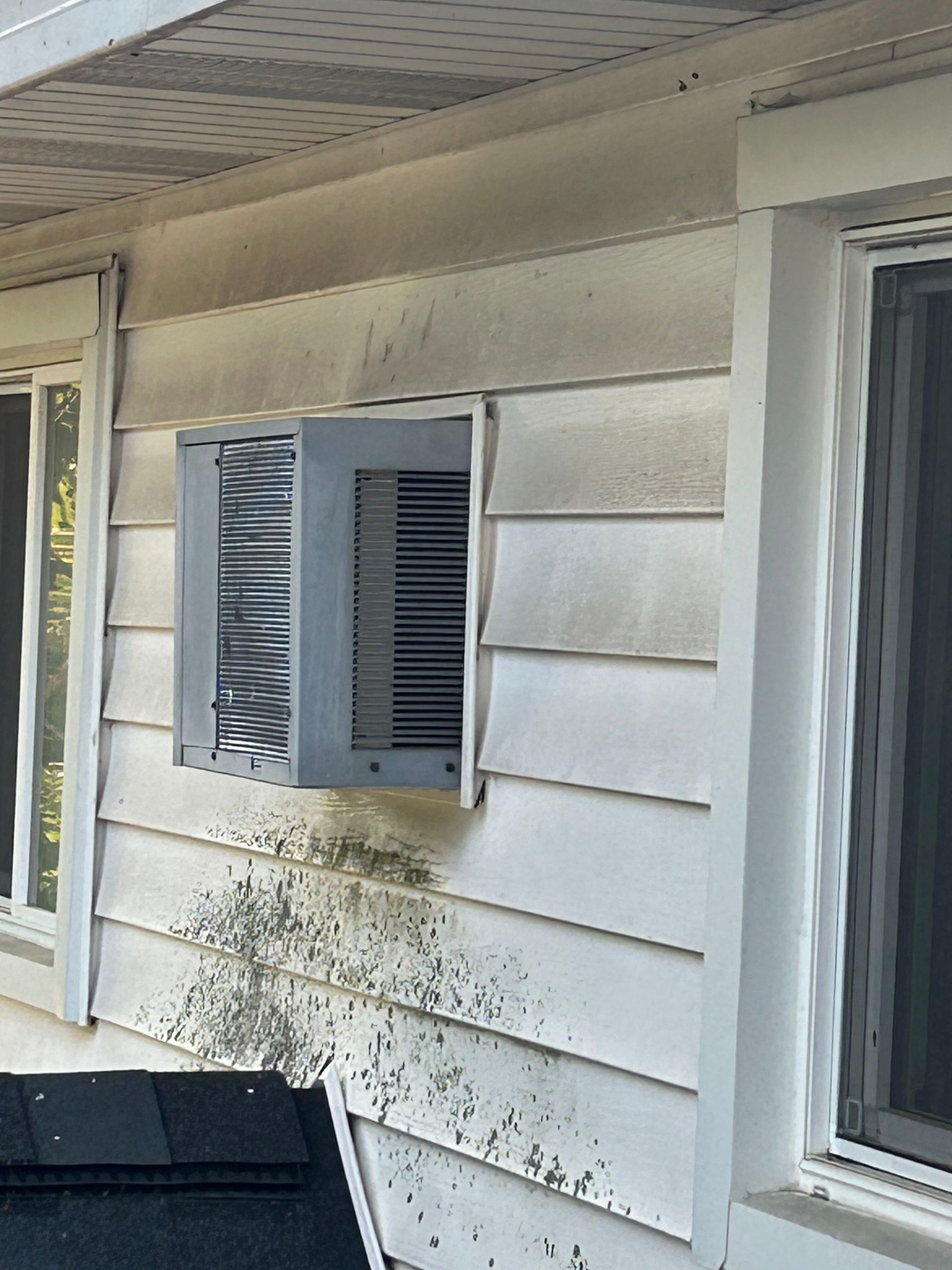 A white house with a black roof and a window