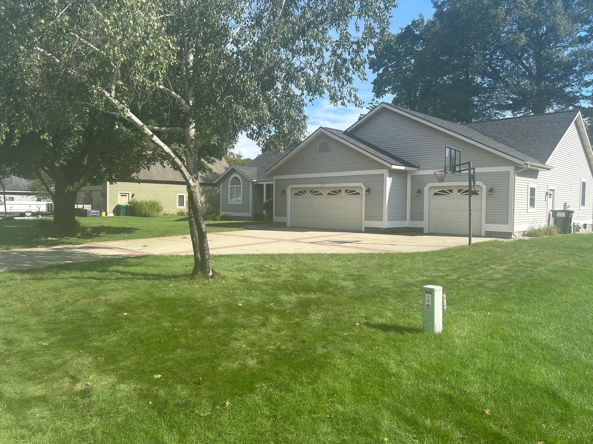 A house with two garage doors and a tree in front of it