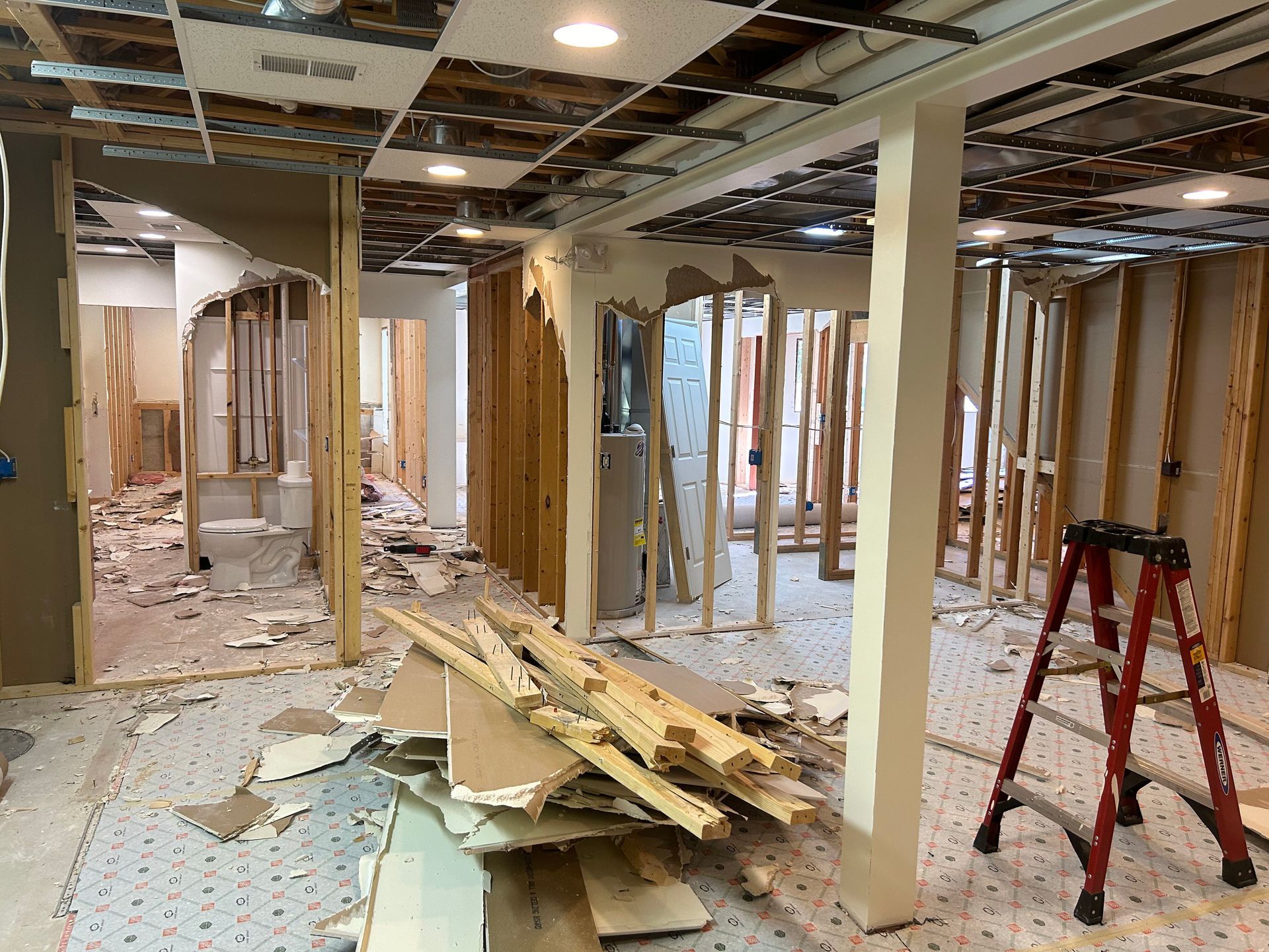 A ladder is sitting in the middle of a room under construction.