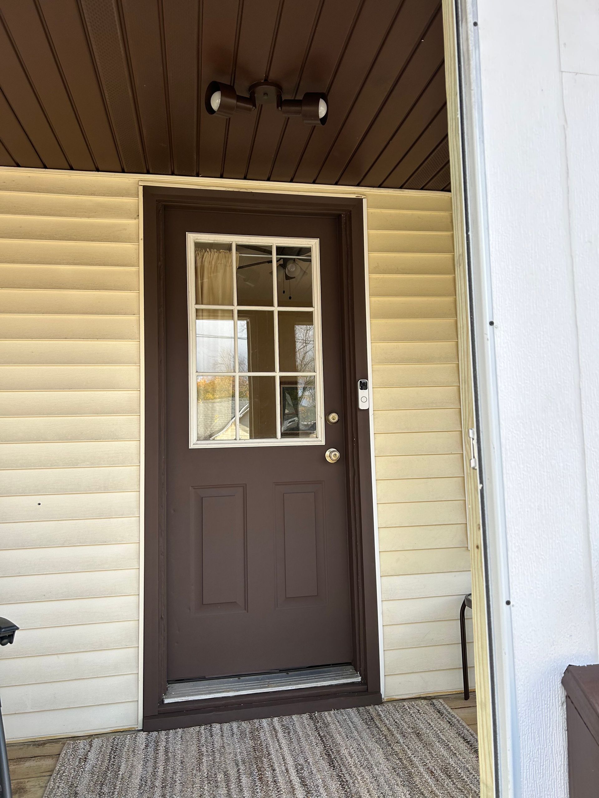A brown door with a window on the side of a house