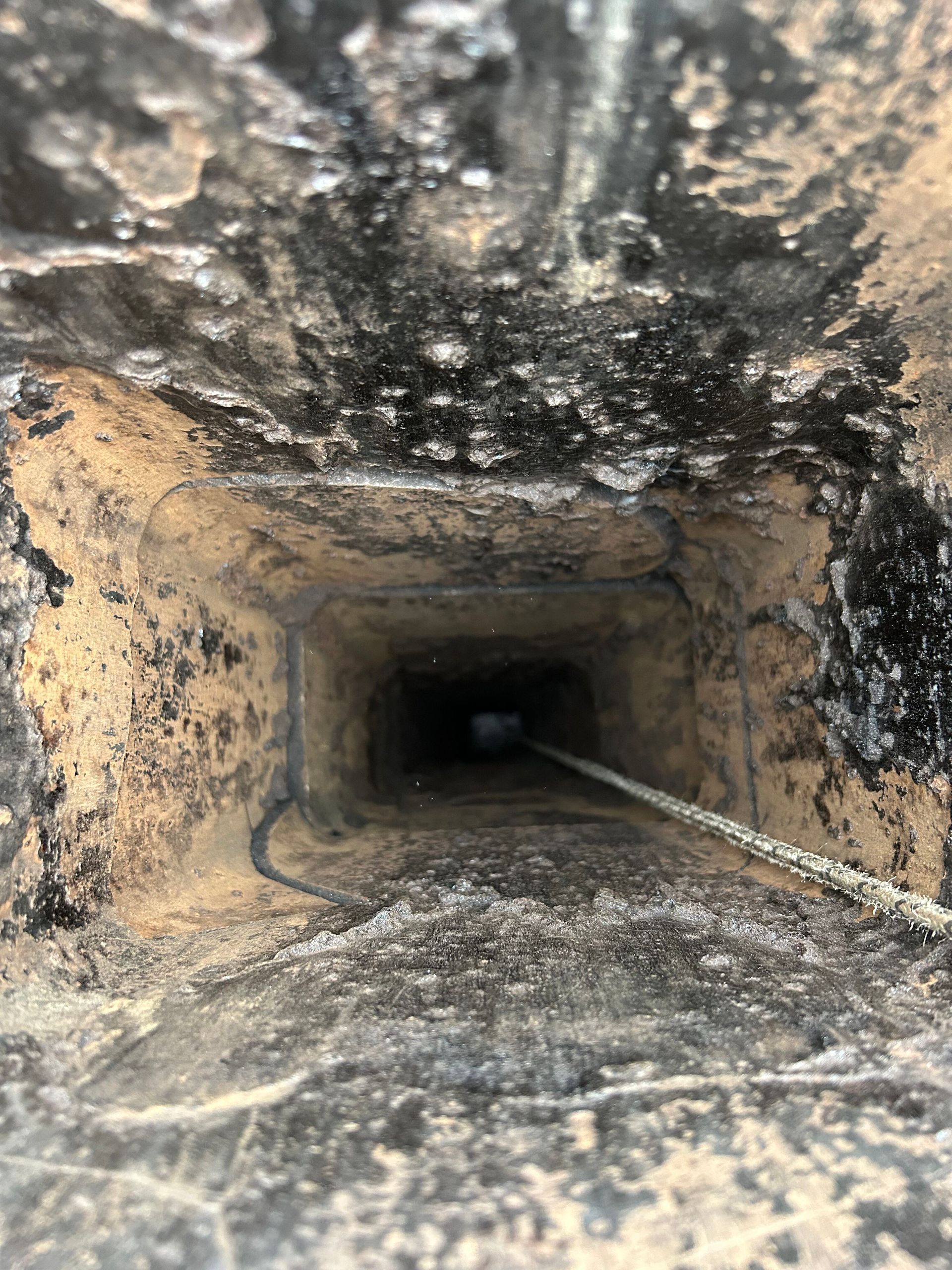 A close up of a chimney with a rope going through it.