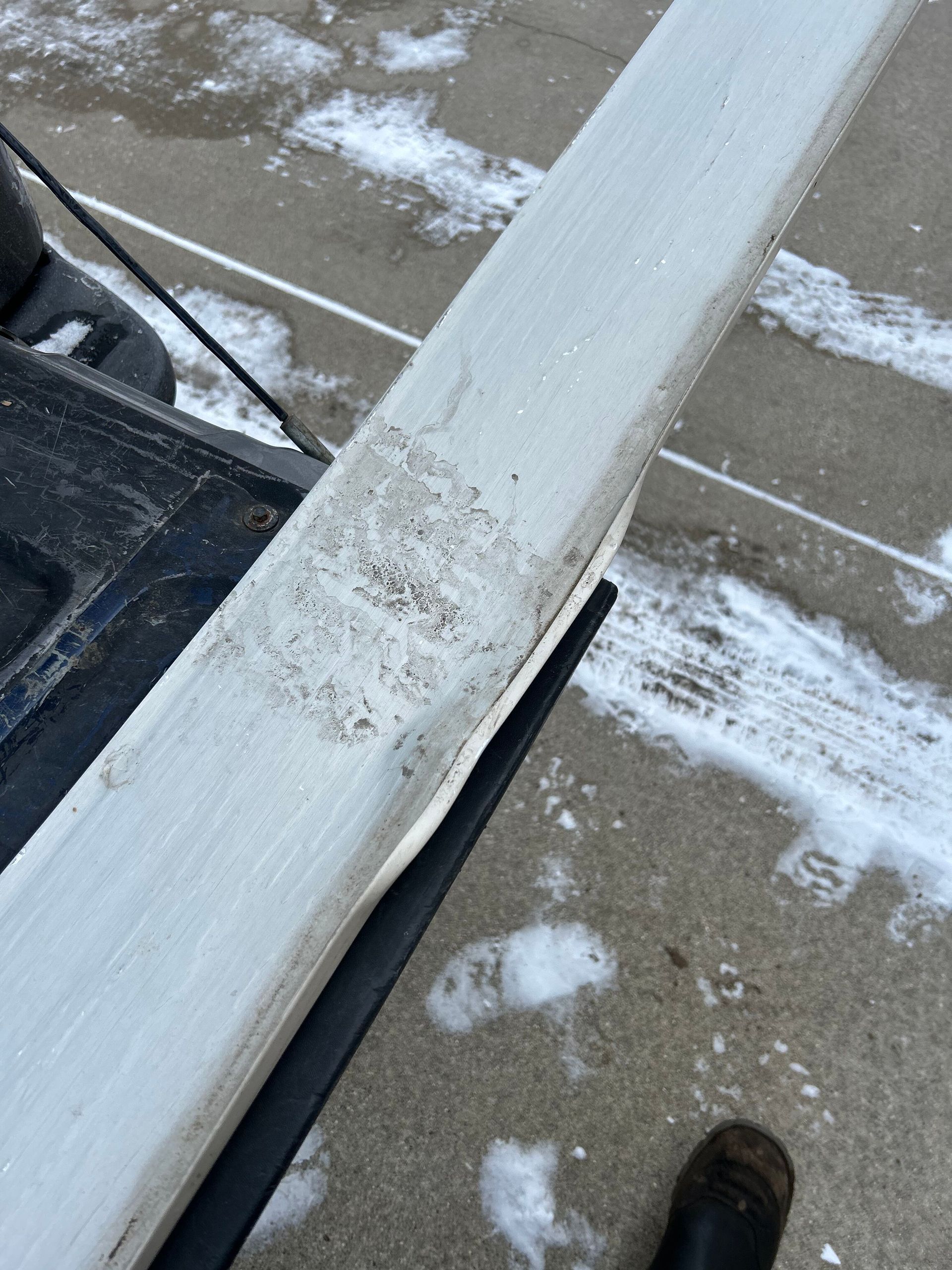 A person is cutting a piece of wood on a concrete surface