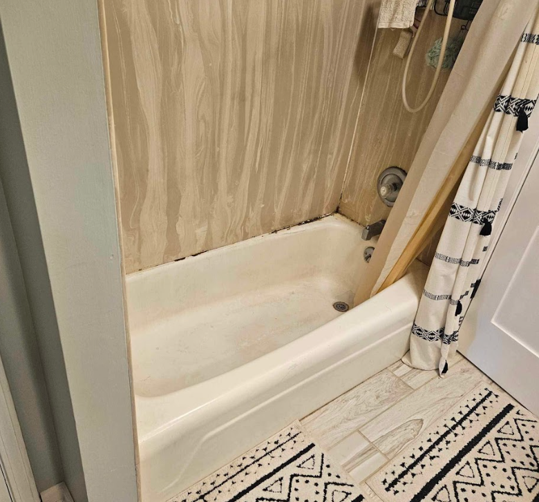 A bathroom with a bathtub and a shower curtain.