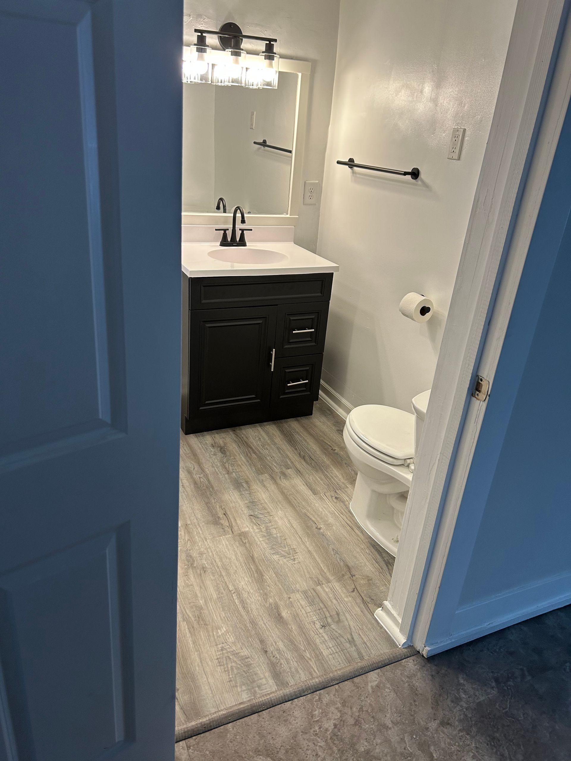 A bathroom with a sink , toilet and mirror.